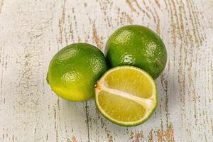 Three limes on a wooden surface photo