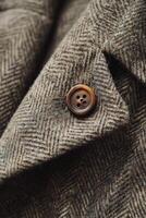Close-up of a classic herringbone fabric with a button detail photo