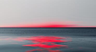 A red sky and water with a reflection photo