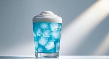 Refreshing cold beverage in glass with ice and foam on top. photo