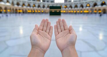Hands raised in prayer in a sacred space with a prominent structure. photo