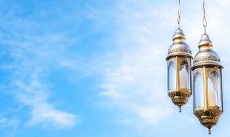 Two ornate lanterns hanging against a blue sky. photo