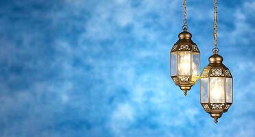 Two ornate hanging lanterns against a blue textured background. photo