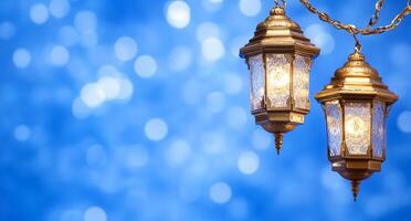 Two ornate lanterns hanging against a soft blue bokeh background. photo