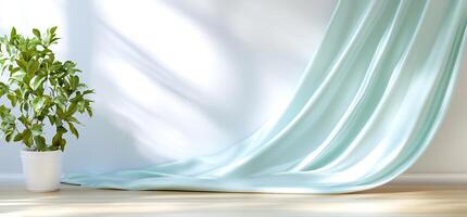 Light teal fabric drapes on floor, plant in pot, sunlit room. Product display photo