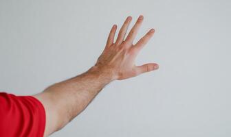 Man's hand reaching, white wall background. Use Website, app, presentation photo