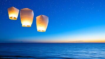 Three glowing lanterns float above a tranquil ocean at dusk. photo