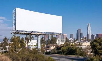A blank billboard stands against a city skyline under a clear sky. photo