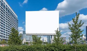 A blank billboard surrounded by greenery and modern buildings. photo