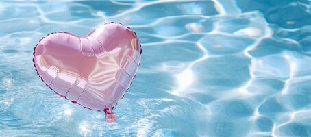A pink heart-shaped balloon floats on shimmering water. photo