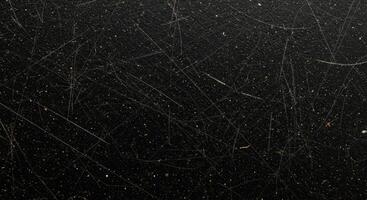 A black surface with some scratches and dirt photo