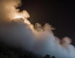 A mountain with a cloud in the sky photo