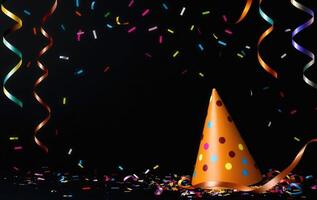 Party hat and confetti on black background photo