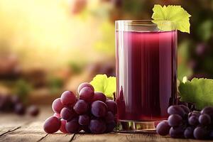Glass of red grape juice with fresh grapes on a wooden table is refreshing photo
