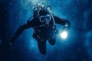 Scuba diver exploring deep ocean with underwater flashlight photo