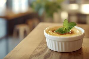 Delicious creme brulee served on a wooden table with mint leaves photo