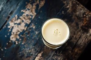 Glass of beer seen from above on rustic wooden table photo