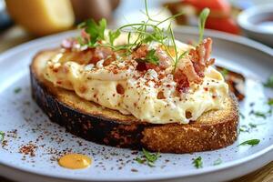 Scrambled eggs with bacon and herbs on toasted bread for breakfast photo
