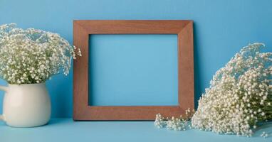 Wooden frame with white flowers on blue background photo
