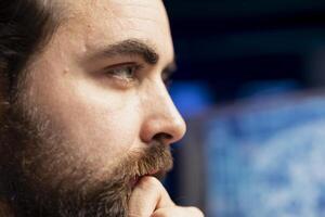 Focus on engineer using PC in blurry background to maintenance artificial intelligence neural networks. Remote IT employee doing checkup on AI systems, close up on face photo