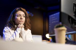 Pensive technician thinking how to design and develop software applications. Contemplative IT specialist brainstorming ways of implementing and maintaining company systems photo