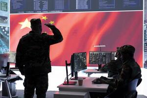 Chinese military officer in uniform monitors critical data on big screen. The national flag is presented in the army operations room, military command center used for propaganda. photo