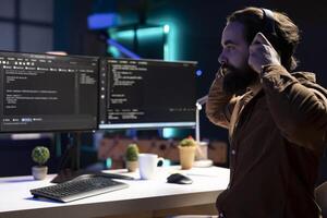 Programmer enjoying podcasts and futureproofing company network from downtimes and unexpected system failures. IT expert putting headphones on to listen audiobooks while increasing data security photo