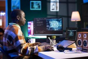 African american man working on computer to write code and programming in artificial intelligence and deep learning. Male IT engineer using pc to ensure cyber security, neural network. photo