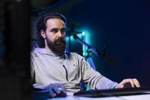 Man talking with audience during livestream, presenting helpful videogame winning strategies from his neon lit studio. Pro gamer chatting with his community, showing game tactics guide to viewers photo