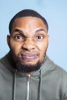 Angry irritated person screaming in front of the camera and showing his frustration, getting aggressive and furious about something. Young adult with mental health problem shows conflict. photo