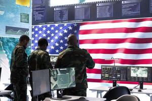American military intelligence officers in a command center monitoring surveillance information in order to safeguard state secrets. Managing security in an army base of operations. photo