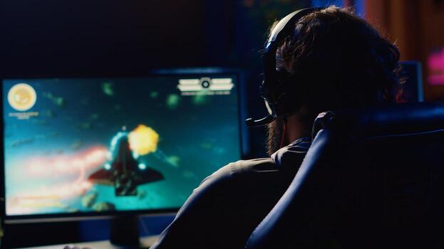 Man talking with friends online, shooting asteroids together in spaceship flying game with overlay HUD showing health, fuel bars. Gamer chatting with teammates while navigating universe in coop game photo