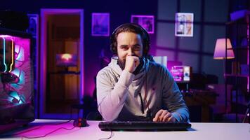 Esports player recording himself playing videogames in front of audience during livestream, providing engaging commentary while battling opponents. Pro gamer participating in gaming competition photo