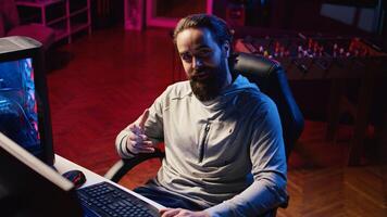 Content creator in studio streaming for online viewers, talking with them about upcoming esports competition. Pro gamer discussing with internet audience watching him during live broadcast photo