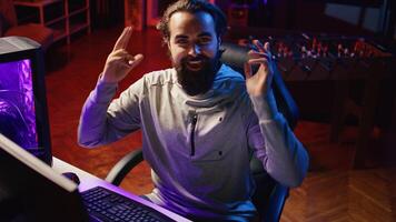 Gamer streaming, greeting audience, preparing to showcase game winning strategy to gaming community during livestream. Content creator chatting with viewers, presenting ways of winning videogame photo