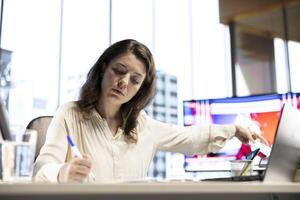 Enterprise director authorizing all work contracts and documents, signing paperwork as CEO with executive power. Solving all her legal obligations in high end modern office, leadership skills. photo