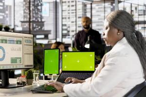 Female general director uses copy space mockup at the workstation, studying online analytics for a project briefing. Woman working in a multinational company, data management. photo