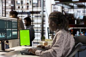 Woman at her desk working on data analysis next to mockup display, engaged in business tasks and budget management to drive effective corporate strategy. Analyst reads reports numbers. photo