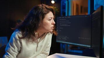 Cybersecurity specialist looking confused at computer screen while trying to fix broken code. Contemplative developer feeling worried and anxious about programming errors, camera B photo