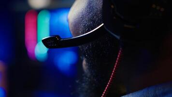 Close up of headset mic used by professional streamer competing in intense online multiplayer videogame live from home. Focus on headphones microphone used by man playing on gaming PC, camera A photo