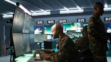 Soldier solving tasks in military HQ base, gathering information on enemy troops. Middle Eastern agent in base of operations doing assessment of enemy vulnerabilities, tracking, camera B photo