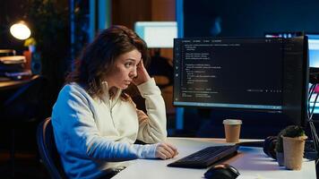 Tired woman hurting from too much stress accumulated while doing software quality assurance on computer. Developer suffers from headache after inspecting coding on PC for too long, camera A photo