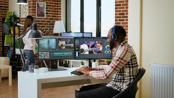 African american filmmaker man works on a professional shoot, managing the editing timeline of a project. Employing modern editing tools and color grading software. Camera A. photo