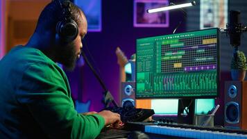 Skilled audio technician editing recorded tracks from an usb stick, using raw files to apply mix and master techniques. Artist producing music, adjusting volume levels on digital software. Camera A. photo