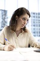 Female CEO solving her business paperwork tasks and signing documents, approving requests from employees and authorizing work contracts in her high end office. Legal management. photo