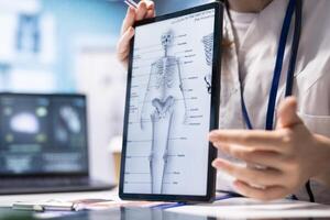 Healthcare professional shows lab test results to patient at consultation, discussing about diagnostic reports with human skeleton illustration. Advanced medical tools to provide accurate analysis. photo