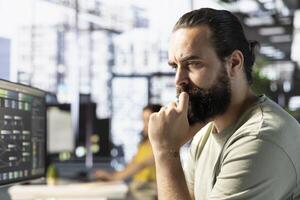 Focused admin thinking how to use cloud computing resources and platforms to train and deploy large scale machine learning models. Close up of employee monitoring and maintaining company systems photo