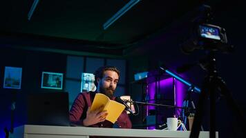 Online show host reading and recommending best reviewed books of the year. Content creator in studio doing novel summaries for interested readers, speaking in professional mic, camera B photo
