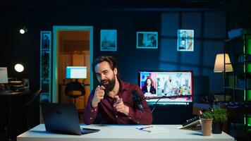 Content creator adjusting professional microphone in studio before starting recording for online vlogging channel. Man in neon lit home studio using equipment for vlog shooting, camera B photo