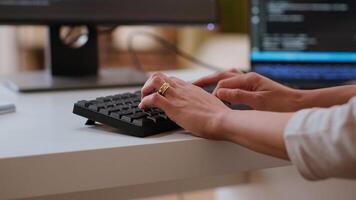 Professional software developer types code on a laptop in a sleek workspace. Asian female freelancer doing remote work on app development, software engineering and agile coding practices. Camera B. photo